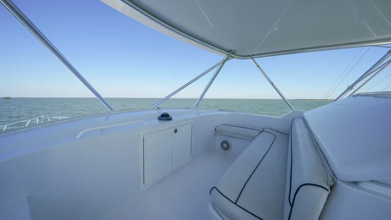 Slide: The Image of Flybridge Seating Area The flybridge of the 2001 Hatteras 60 Convertible offers a spacious seating area with plush, cushioned benches. The clean, white finish provides a sleek, modern look, while the expansive views of the open water enhance the cruising experience. This area i - 8734364