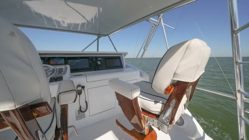 Slide: The Image of Flybridge Helm Station with Seating The flybridge of the 2001 Hatteras 60 Convertible showcases a well-equipped helm station with dual captain's chairs. The sleek design includes polished wooden accents and integrated navigation systems, offering a commanding view of the open sea. This area - 8734362