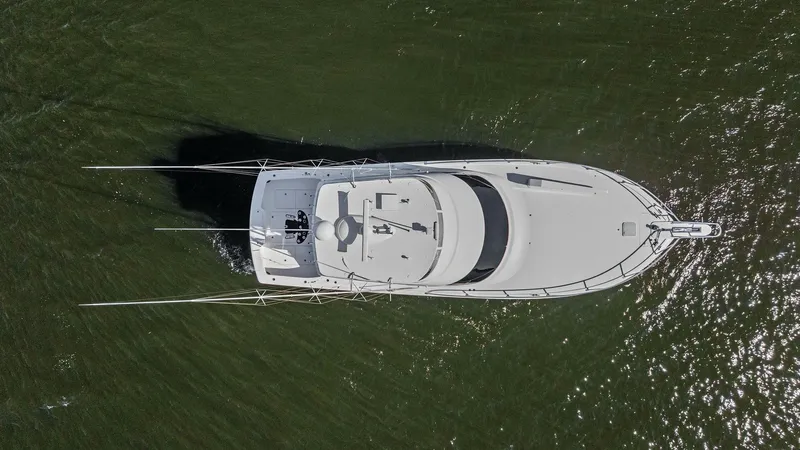 Slide: The Image of Aerial View of Flybridge and Deck This aerial shot showcases the sleek design of the Viking 54 Convertible, highlighting its spacious flybridge and streamlined deck layout. The vessel's modern aesthetic is complemented by its sturdy construction, designed for both luxury and performance. - 8673354