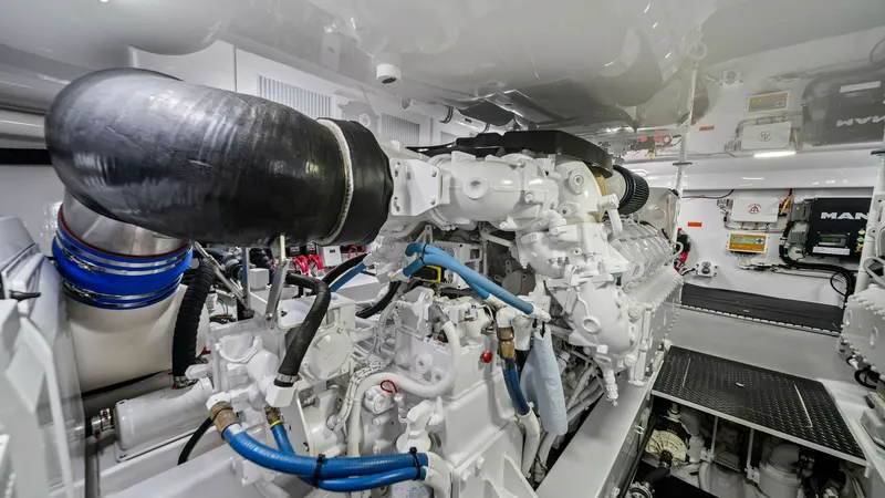 Slide: The Image of Engine Room with Twin Engines The engine room of the 2021 Viking 54 Convertible showcases powerful twin engines, meticulously maintained for optimal performance. The space is well-organized with easy access to all components, featuring advanced engineering and robust piping systems. B - 8673341