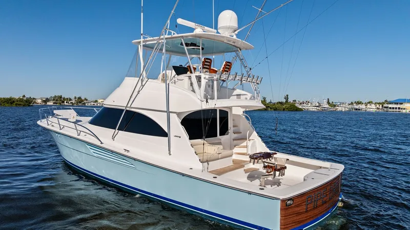 Slide: The Image of Aft Deck and Flybridge View The Viking 54 Convertible's expansive aft deck is designed for both leisure and sportfishing, featuring a well-equipped fighting chair and ample seating. The flybridge offers elevated views and is fitted with advanced navigation equipment and comfortable - 8673351