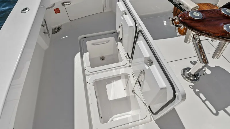 Slide: The Image of Cockpit with Storage Hatches The Viking 54 Convertible's cockpit features spacious underfloor storage hatches, perfect for stowing gear or catch. The sleek, white finish enhances the modern aesthetic, while the teak fighting chair adds a touch of elegance and functionality. This area - 8673333