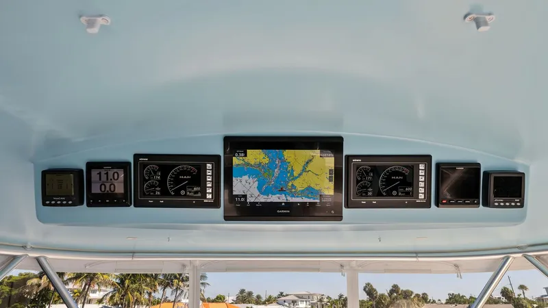 Slide: The Image of Flybridge Helm Electronics Display The flybridge helm of the 2021 Viking 54 Convertible 'Pipe Dream' showcases a state-of-the-art electronics display. Central to the helm is a large multi-function display, providing navigational charts and essential data for seamless maritime navigation. F - 8673323