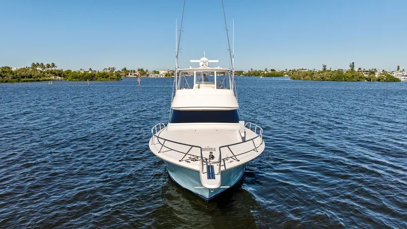 Slide: The Image of Bow View of Viking 54 Convertible The sleek and commanding bow of the 2021 Viking 54 Convertible, 'Pipe Dream,' is showcased against a serene water backdrop. The vessel's streamlined design is accentuated by its clean lines and robust bow rail, highlighting its prowess in open waters. The - 8673347