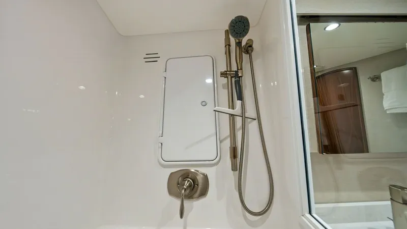 Slide: The Image of En-Suite Bathroom Shower Detail This image showcases the sleek and modern design of the en-suite bathroom shower on the 2021 Viking 54 Convertible. The shower features a high-quality, adjustable showerhead and elegant chrome fixtures, providing both functionality and style. The white, g - 8673315
