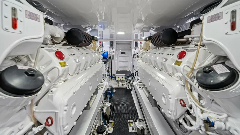 Slide: The Image of Engine Room with Twin MAN Engines The engine room of the 2021 Viking 54 Convertible showcases twin MAN engines, emphasizing power and reliability. The immaculate space features well-organized systems and high-quality components, ensuring optimal performance. Bright lighting and a clean la - 8673344