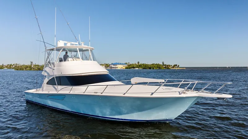 Slide: The Image of Starboard Bow View The 2021 Viking 54 Convertible showcases its sleek starboard bow with a striking blue hull. The design features a spacious foredeck and sturdy railings, emphasizing both elegance and functionality for offshore adventures. The flybridge with its commanding - 8673348