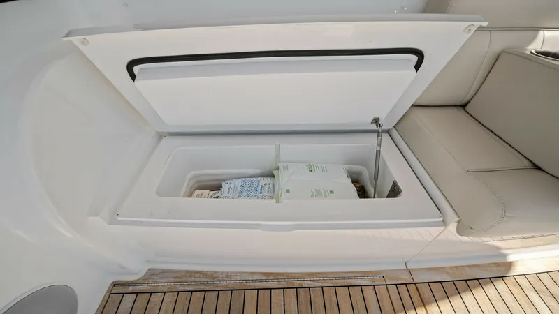 Slide: The Image of Cockpit Storage Compartment This image showcases the convenient cockpit storage compartment on the 2021 Viking 54 Convertible. The compartment features a sleek, integrated design with a hydraulic lift for easy access. The teak decking adds a touch of elegance, complementing the comf - 8673336