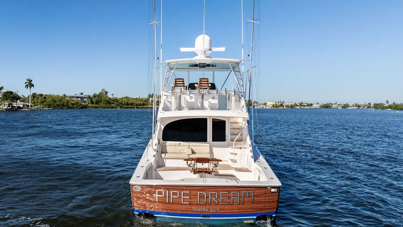 Slide: The Image of Aft View with Cockpit Seating The aft view of the Viking 54 Convertible 'Pipe Dream' showcases a spacious cockpit with comfortable seating, ideal for relaxing or entertaining. The teak deck enhances the luxurious feel, while the fishing chair is a testament to the yacht's sportfishing - 8673352