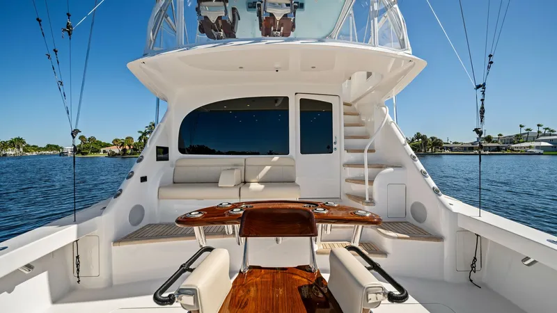 Slide: The Image of Spacious Aft Deck with Seating The aft deck of the 2021 Viking 54 Convertible 'Pipe Dream' offers a luxurious and functional space for fishing and relaxation. Featuring a polished teak fighting chair and ample cushioned seating, this area is designed for comfort and efficiency. The cle - 8673329