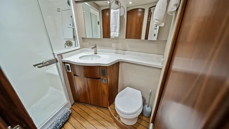 Slide: The Image of Elegant Ensuite Bathroom This luxurious ensuite bathroom features a sleek glass-enclosed shower and elegantly curved vanity. The rich wood cabinetry and flooring create a warm, inviting atmosphere, complemented by modern fixtures and ample storage. The space is thoughtfully desig - 8673314