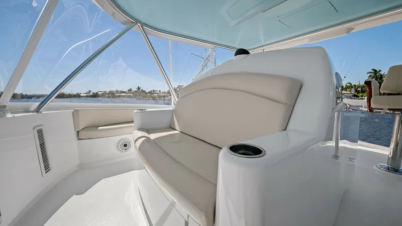 Slide: The Image of Flybridge Seating Area The flybridge of the Viking 54 Convertible features a plush seating area with a comfortable, upholstered bench. The expansive windows provide panoramic views, enhancing the open-air experience. Sleek finishes and integrated cup holders add to the function - 8673324