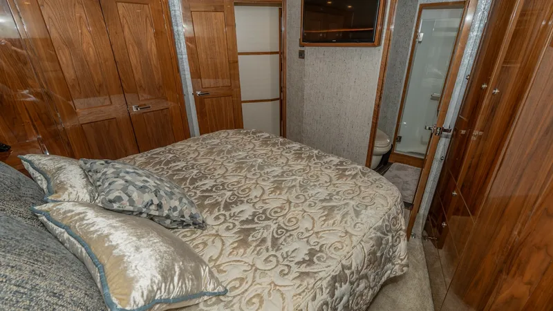 Slide: The Image of Master Stateroom with Ensuite Access The master stateroom offers a luxurious retreat with its plush bedding and elegant wood finishes. A flat-screen TV is mounted for entertainment, while the ensuite bathroom provides convenient access. Ample natural light enhances the room's warm and inviti - 8738035