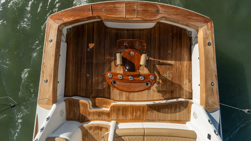 Slide: The Image of Aft Deck with Teak Flooring The aft deck of the 2019 Viking 68 Enclosed Bridge, Sandman, features exquisite teak flooring that enhances its luxurious appeal. A well-crafted fighting chair is centrally positioned, ideal for sportfishing enthusiasts. The surrounding padded coaming pro - 8738067