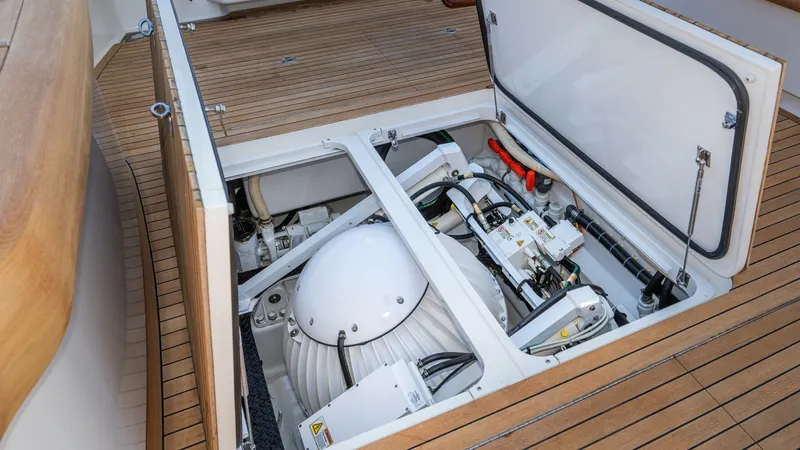 Slide: The Image of Engine Compartment Access Hatch The image showcases the engine compartment of the Viking 68 Enclosed Bridge, featuring a neatly organized array of mechanical and electrical components. The hatch provides easy access for maintenance, set against the vessel's high-quality teak decking. Th - 8738048