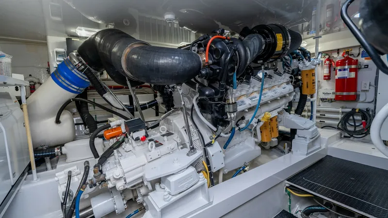 Slide: The Image of Engine Room with Twin Engines The engine room of the 2019 Viking 68 Enclosed Bridge features powerful twin engines, meticulously maintained for peak performance. The space is well-organized with clearly labeled components, ensuring easy access for maintenance and inspections. Bright l - 8738068