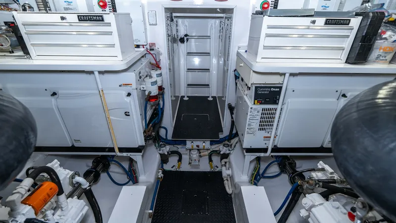 Slide: The Image of Engine Room with Storage Units This image showcases the well-organized engine room of the 2019 Viking 68 Enclosed Bridge. It features ample storage solutions with built-in Craftsman tool chests and neatly arranged systems, ensuring efficient space utilization. The bright lighting and a - 8738081