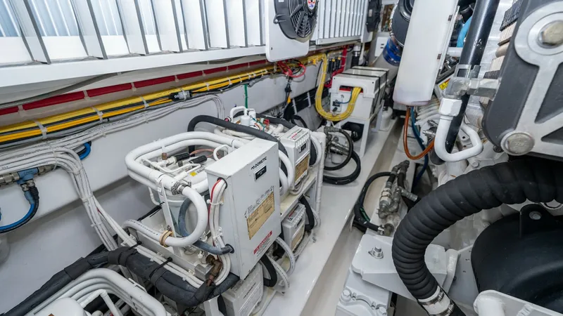 Slide: The Image of Well-Equipped Engine Room The engine room of the 2019 Viking 68 Enclosed Bridge showcases a meticulously organized layout, featuring advanced machinery and systems for optimal performance. The space is efficiently arranged with clean, accessible wiring and robust cooling systems, - 8738078