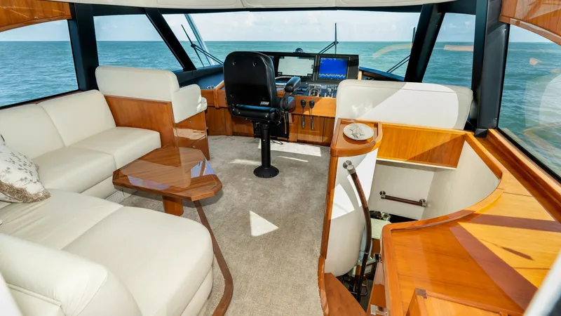 Slide: The Image of Enclosed Bridge Helm and Lounge Area The enclosed bridge of the 2019 Viking 68 Enclosed Bridge offers a luxurious helm with state-of-the-art navigation equipment, surrounded by expansive ocean views. The plush seating area features elegant leather upholstery and rich wood finishes, creating - 8738023