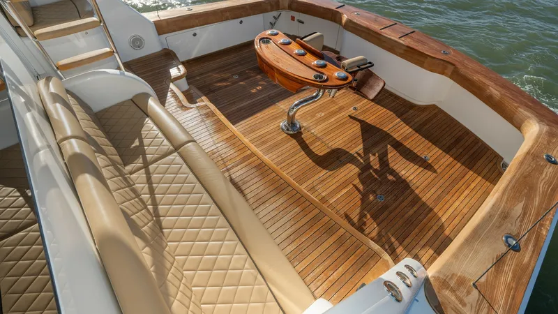 Slide: The Image of Aft Deck with Fighting Chair The aft deck of the 2019 Viking 68 Enclosed Bridge showcases a spacious teak platform, ideal for fishing or relaxation. Featuring a high-quality fighting chair, this area is designed for serious anglers. The elegant diamond-stitched seating and polished w - 8738058