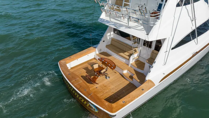 Slide: The Image of Aft Deck with Fishing Setup The aft deck of the 2019 Viking 68 Enclosed Bridge showcases a spacious teak fishing area, complete with a central fighting chair. The integrated rod holders and ample seating provide functionality and comfort for fishing enthusiasts. This well-designed s - 8738095