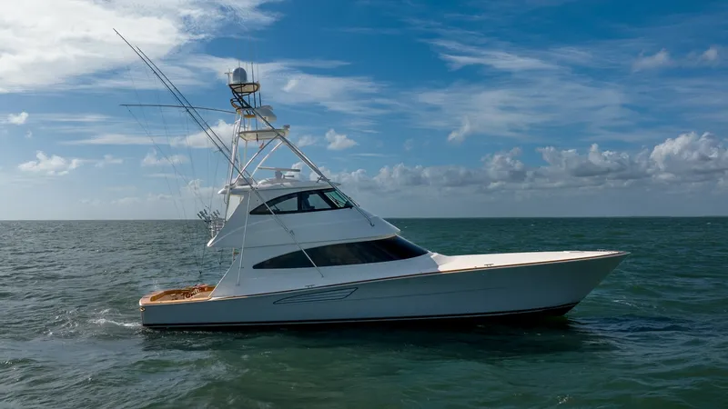 Slide: The Image of Side Exterior View of Viking 68 This image showcases the sleek side profile of the 2019 Viking 68 Enclosed Bridge. The vessel's modern design is highlighted by its streamlined hull and expansive bridge, ideal for luxurious cruising. With robust fishing equipment and a polished white fin - 8738091