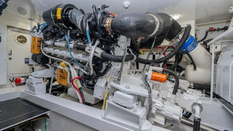 Slide: The Image of Engine Room with Dual Engines The engine room of the 2019 Viking 68 Enclosed Bridge showcases powerful dual engines, meticulously organized with precision engineering. The space is designed for optimal performance and accessibility, featuring advanced systems and clean installations. - 8738069