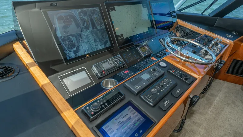 Slide: The Image of Helm Station with Advanced Navigation The helm station of the 2019 Viking 68 Enclosed Bridge showcases state-of-the-art navigation technology. Featuring multiple high-resolution displays, a sleek stainless-steel steering wheel, and an array of control panels, the area is designed for optimal - 8738021