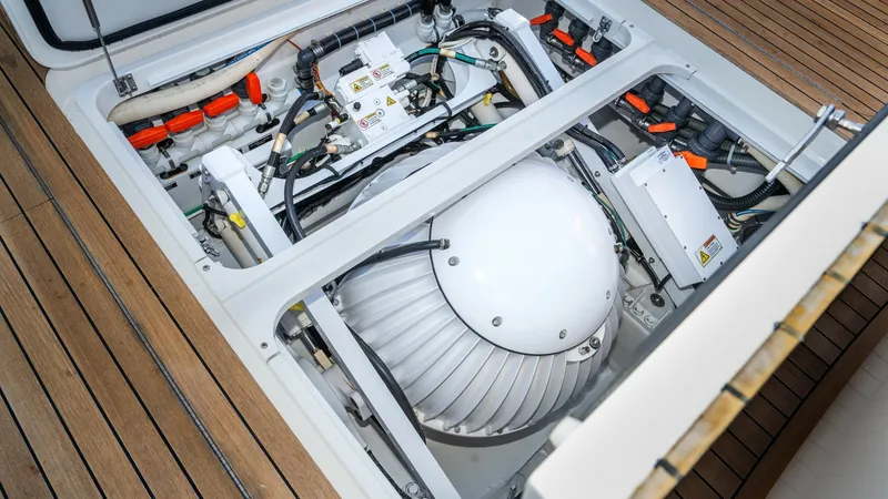 Slide: The Image of Engine Room Access Hatch This image showcases the well-organized engine room of the 2019 Viking 68 Enclosed Bridge. The clean layout highlights the advanced equipment and wiring, ensuring optimal performance and easy maintenance. The teak flooring around the hatch adds a touch of - 8738049