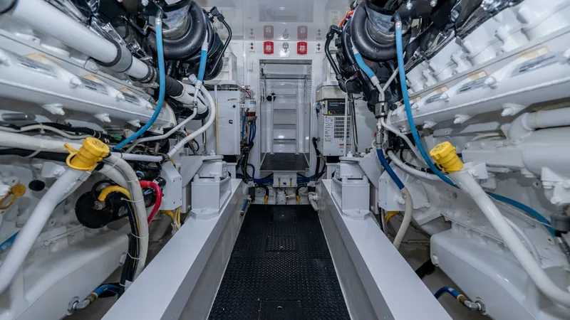 Slide: The Image of Engine Room with Dual Engines The engine room of the 2019 Viking 68 Enclosed Bridge 'Sandman' showcases a meticulously organized layout featuring dual powerful engines. The space is designed for optimal functionality, with clearly labeled components and accessible pathways. High-quali - 8738080