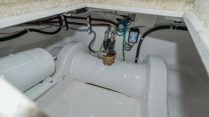 Slide: The Image of Engine Compartment Plumbing Details This image showcases the neatly organized plumbing system within the engine compartment of the 2019 Viking 68 Enclosed Bridge. Visible are the high-quality fittings and hoses, indicative of the vessel's superior engineering. The clean, white finish highli - 8738034