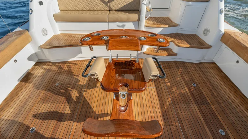 Slide: The Image of Teak Cockpit with Fighting Chair This image showcases the luxurious teak cockpit of the 2019 Viking 68 Enclosed Bridge, featuring a high-end fighting chair ideal for serious anglers. The cockpit's elegant design includes built-in cushioned seating, creating a comfortable and practical sp - 8738053