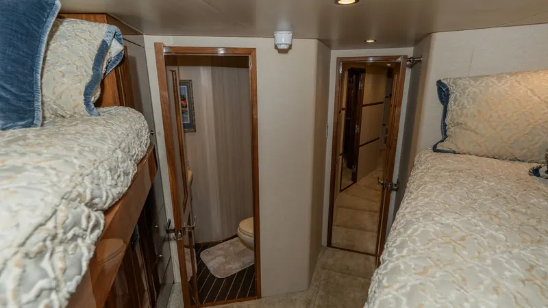 Slide: The Image of Guest Cabin with Twin Berths This cozy guest cabin features twin berths with plush bedding, providing a comfortable retreat for guests. The warm wood accents and soft lighting create an inviting atmosphere. Adjacent to the cabin is a convenient ensuite bathroom, enhancing privacy and - 8738045