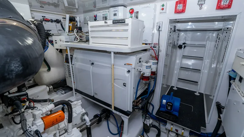 Slide: The Image of Engine Room with Equipment Storage The engine room of the 2019 Viking 68 Enclosed Bridge is meticulously organized, featuring advanced mechanical systems and ample storage. Key highlights include a Craftsman toolbox and state-of-the-art equipment neatly arranged for easy access. The well-l - 8738076