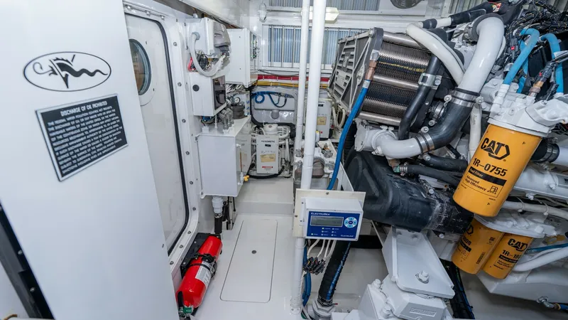 Slide: The Image of Engine Room with CAT Engines The engine room of the 2019 Viking 68 Enclosed Bridge 'Sandman' features advanced CAT marine engines, showcasing superior engineering and reliability. The space is meticulously organized, with clearly labeled components and accessible pathways. High-quali - 8738079