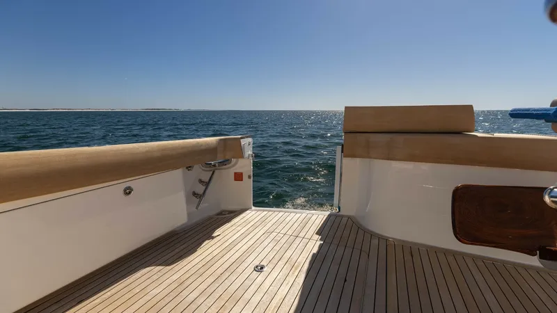 Slide: The Image of Spacious Teak Cockpit Deck View The cockpit of the 2019 Viking 68 Convertible offers a spacious teak deck, perfect for fishing or relaxing at sea. The high-quality wood finishes provide both durability and elegance, complementing the open view of the ocean. This area is designed for bot - 8679297