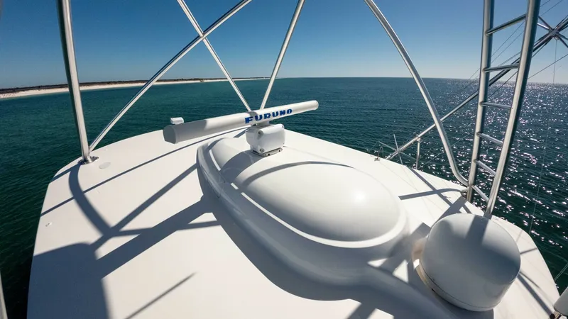 Slide: The Image of Flybridge with Radar Equipment This image captures the flybridge of the 2019 Viking 68 Convertible, showcasing its state-of-the-art radar system. The open-air design offers panoramic views of the ocean, ideal for navigation and leisure. The sleek, modern equipment is complemented by st - 8679289