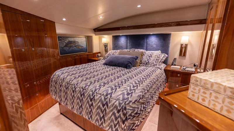Slide: The Image of Luxurious Master Stateroom This elegant master stateroom on the Viking 68 Convertible features a plush queen-sized bed with stylish bedding. Rich wood finishes complement the soft, ambient lighting, creating a warm and inviting atmosphere. Ample storage and sophisticated decor make - 8679268