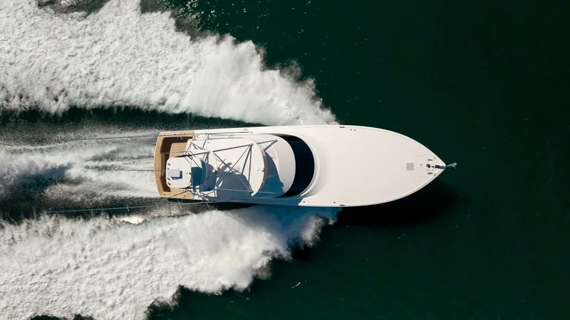 Slide: The Image of Aerial View of Yacht in Motion This dynamic aerial shot captures the Viking 68 Convertible 'Gas Money' slicing through the water with impressive speed and grace. The sleek hull design ensures efficient performance, while the spacious aft deck is perfect for both relaxation and fishing. - 8679312