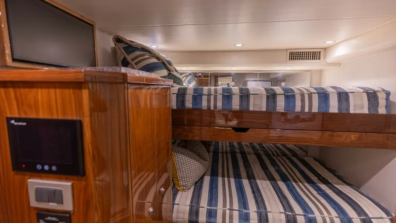 Slide: The Image of Guest Cabin with Bunk Beds This cozy guest cabin features stylish bunk beds with striped bedding, providing ample sleeping space for guests. The warm wood finishes add a touch of elegance, complemented by modern lighting and a convenient control panel. Ideal for comfortable overnig - 8679280