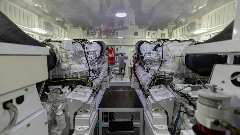 Slide: The Image of Engine Room with Dual Engines This image showcases the meticulously organized engine room of the 2019 Viking 68 Convertible, featuring dual powerful engines. The space is designed for functionality and efficiency, with clearly labeled components and ample lighting for easy maintenance - 8679300