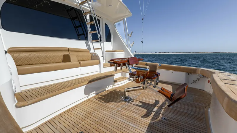 Slide: The Image of Spacious Aft Deck with Seating and Fishing Chair The Viking 68 Convertible's aft deck offers a perfect blend of luxury and functionality, featuring a richly appointed seating area with elegant cushioning. The deck is equipped with a professional-grade fighting chair, ideal for serious sportfishing enthu - 8679259