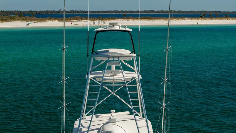 Slide: The Image of Flybridge with Tower View This image showcases the Viking 68 Convertible's sleek flybridge and tower, set against a stunning backdrop of turquoise waters. The flybridge offers a commanding view, perfect for both navigation and relaxation. The sturdy construction and elegant design - 8679288