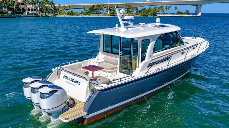 Slide: The Image of Aft Deck with Triple Outboards The Back Cove 390's aft deck features a spacious seating area with a sleek table, perfect for outdoor relaxation and dining. Equipped with powerful triple outboard engines, this yacht promises exceptional performance on the water. The elegant design is co - 8738163
