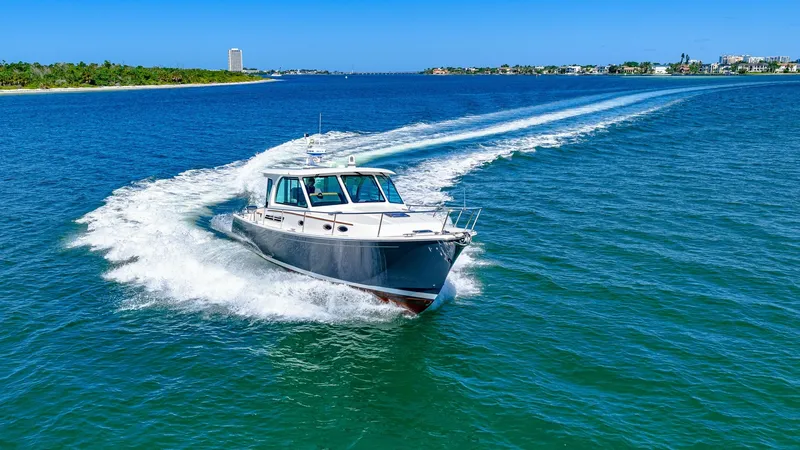 Slide: The Image of Bow View Cruising at Speed The 2022 Back Cove 390 'Risk and Reward' is captured slicing through the water with elegance and power. The bow displays a sleek design, cutting cleanly through the waves, while the cabin windows offer a glimpse of the spacious interior. This yacht's perf - 8738172