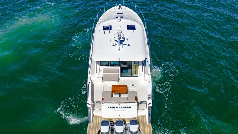 Slide: The Image of Aerial View of Aft Deck and Engines This aerial shot of the Back Cove 390 highlights the spacious aft deck, featuring a comfortable seating area with a wooden table for alfresco dining. The powerful quad outboard engines are prominently displayed, showcasing the vessel's capability for high - 8738164