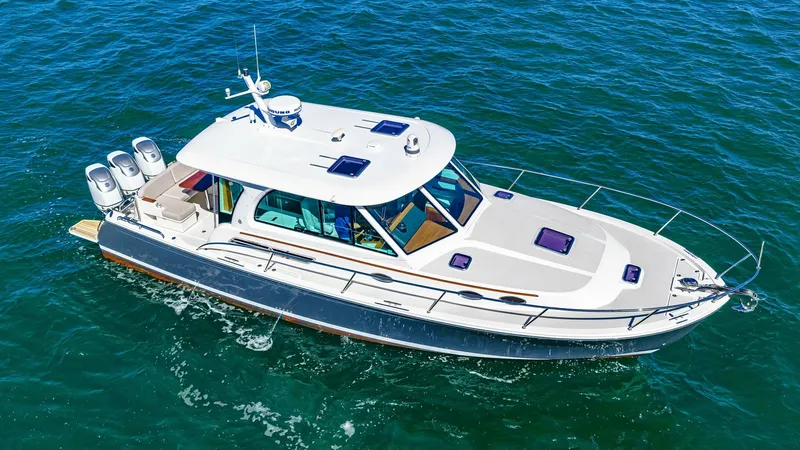 Slide: The Image of Aerial View of Back Cove 390 This aerial shot showcases the sleek design of the 2022 Back Cove 390, 'Risk and Reward.' The vessel features a spacious foredeck with stainless steel railings and strategically placed hatches for ventilation and natural light. The modern, streamlined cab - 8738162