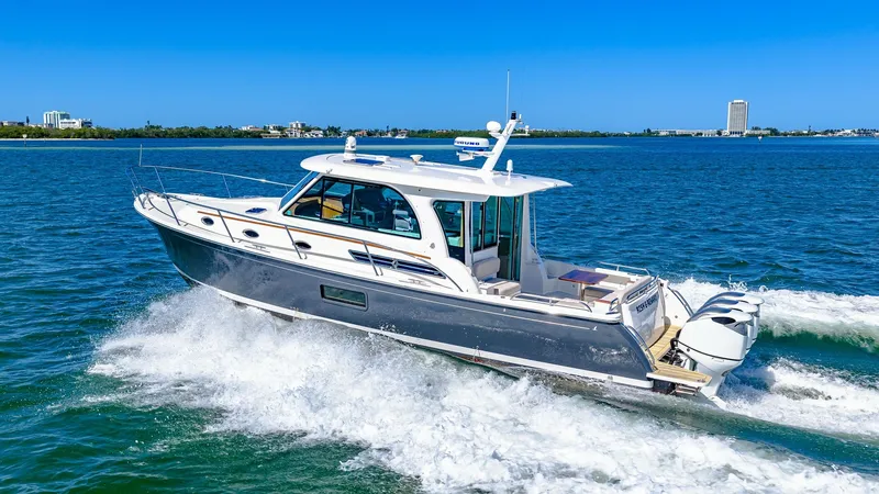 Slide: The Image of Side Profile Cruising View The 2022 Back Cove 390 'Risk and Reward' glides gracefully across the water, showcasing its sleek design and modern lines. The side profile highlights the elegant hull and spacious cockpit, perfect for both leisure and adventure. The vessel's sophisticate - 8738169