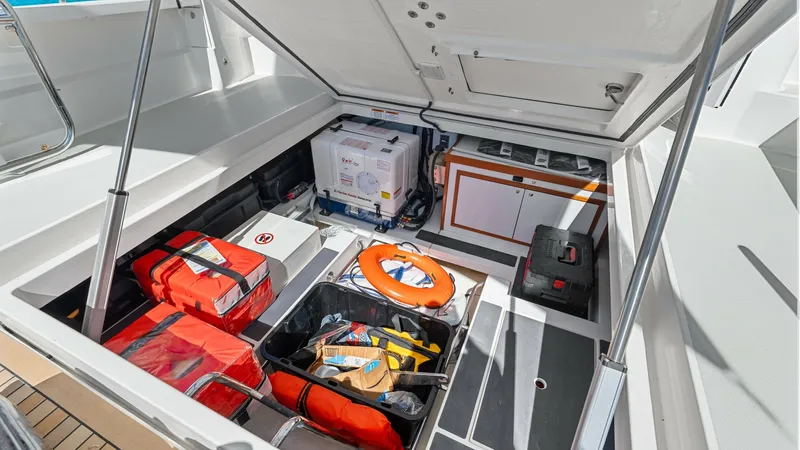 Slide: The Image of Spacious Aft Storage Compartment The image showcases the spacious aft storage compartment of the 2022 Back Cove 390, 'Risk and Reward'. This well-organized area is equipped with essential safety gear, including life jackets and a life ring, ensuring readiness for any situation. The stora - 8738148