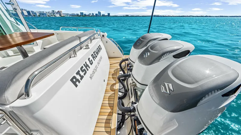 Slide: The Image of Aft Deck with Triple Engines The aft deck of the Back Cove 390 features a spacious, teak-finished area with comfortable bench seating. Prominently displayed are the powerful triple outboard engines, providing impressive performance and reliability. This section offers a perfect blend - 8738152